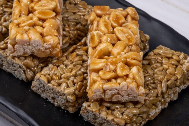 Close up view of honey bars with peanuts and sunflower seeds on black