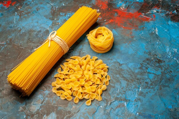 Close up view of Italian various pastas for dinner preparation on the right side on blue background
