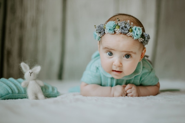 Close up view of little female girl lying on the bed and looking at the camera