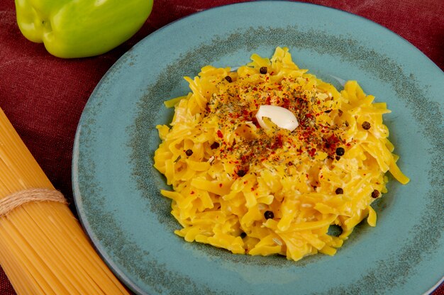 ボルドー布に唐辛子と春雨のプレートにマカロニパスタのクローズアップビュー