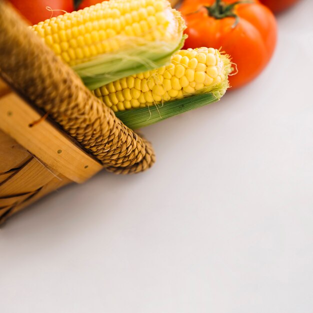 Close up view of maize and tomatoes in basket