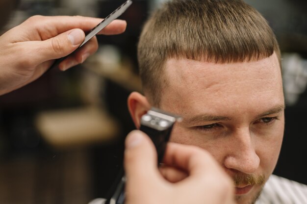 Close-up view of man getting a haircut