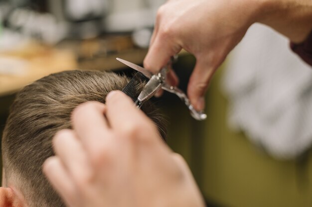 Close-up view of man getting a haircut