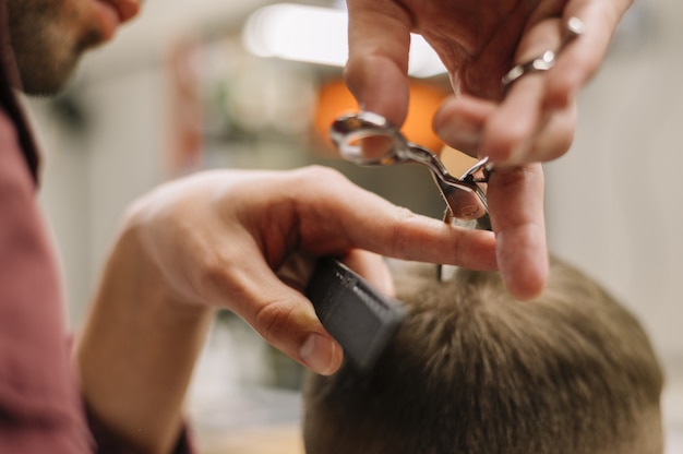 Close-up view of man getting a haircut