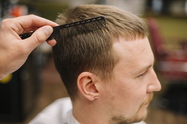 Close-up view of man getting a haircut