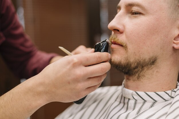 Close-up view of man shaving his beard