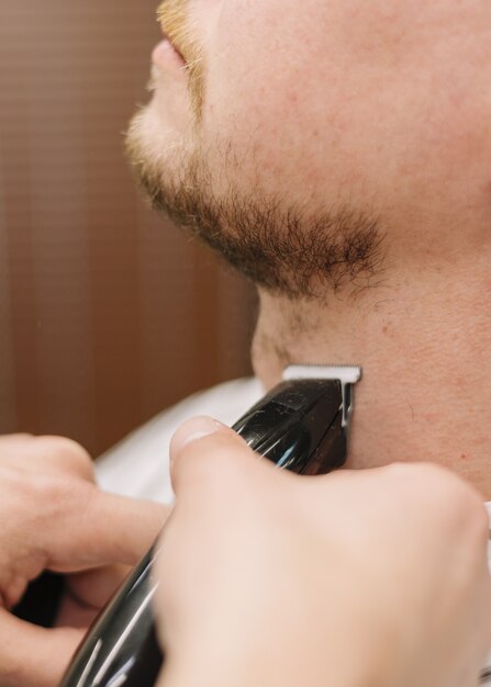 Close-up view of man shaving his beard