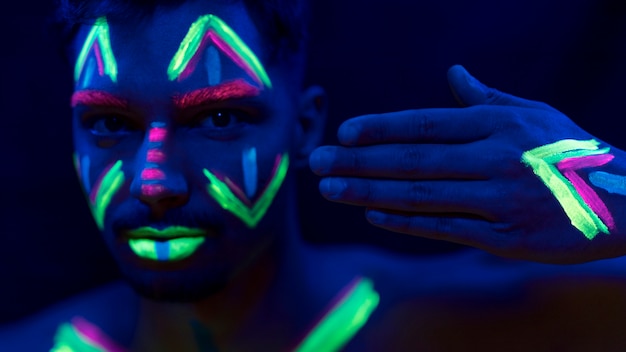 Close-up view of man with colorful fluorescent make-up