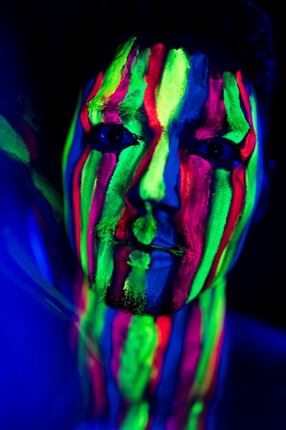 Close-up view of man with fluorescent make-up