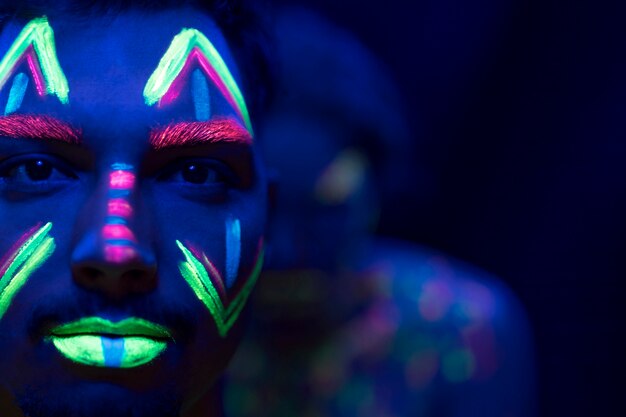 Close-up view of man with fluorescent make-up