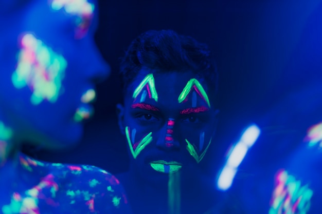 Free photo close-up view of man with fluorescent make-up