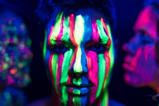 Close-up view of man with fluorescent make-up