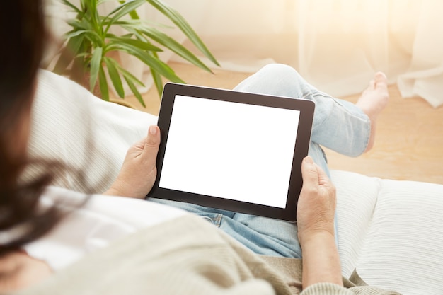 Close up to view mature woman's hands hold black tablet with empty screen