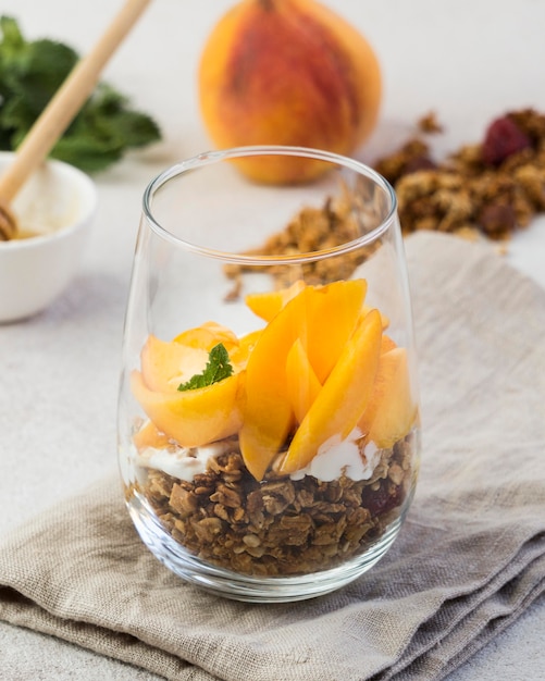 Close-up view of muesli with peaches in glass