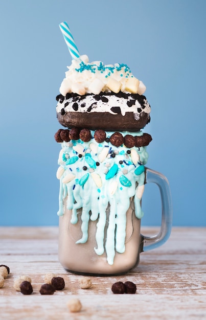 Free photo close-up view of a mug of milkshake on wooden background