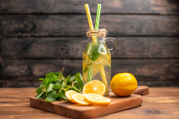 Free photo close up view of natural fresh detox water served with tube mint and orange on a brown background