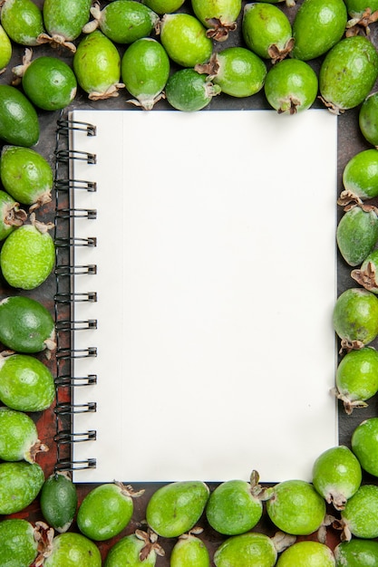 Close up view of notebook among fresh natural green feijoas