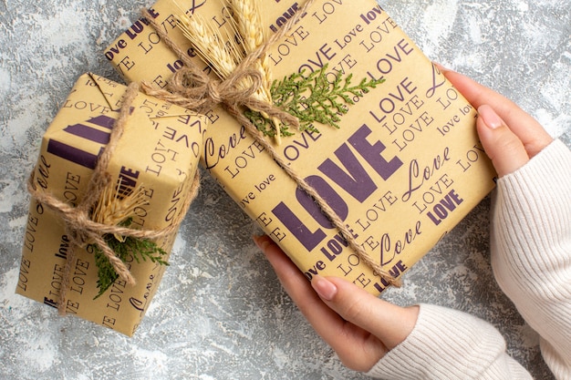 Бесплатное фото Крупным планом вид руки, держащей красивый упакованный подарок на рождество на ледяной поверхности