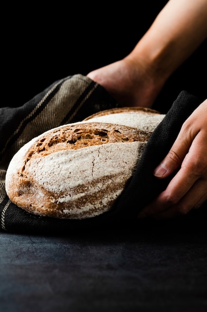 Бесплатное фото Взгляд конца-вверх рук держа хлеб