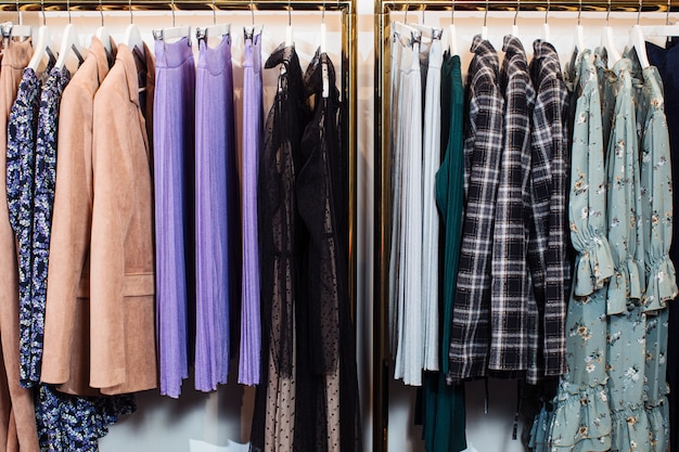 ブティックのハンガーに掛かっている様々なスタイリッシュな服のクローズアップビュー 服 プレミアム写真