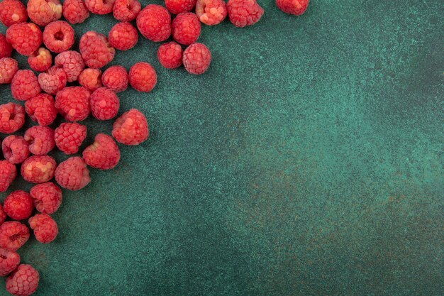 Close up view of pattern of raspberries on green surface