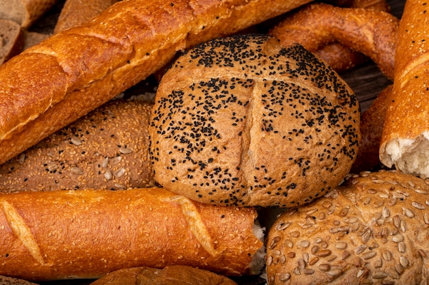 Close-up view of poppy seed cob with baguette and other breads