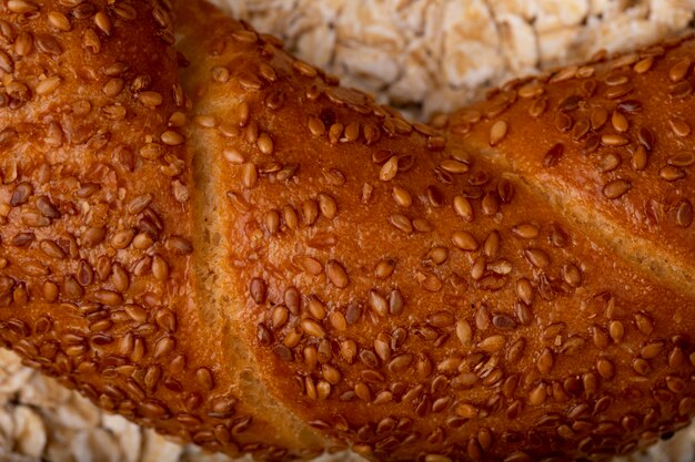 Vista del primo piano dei semi di papavero sul bagel sul fondo dell'avena