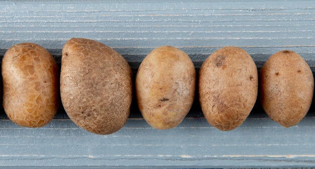 Close up view of potatoes on wooden background with copy space