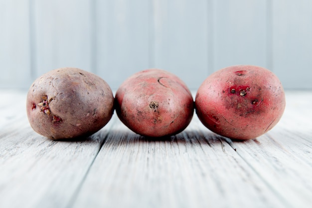 Close up view of potatoes on wooden surface and background with copy space