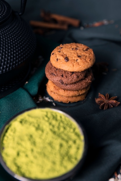 Foto gratuita tè verde della polvere di vista del primo piano con i biscotti