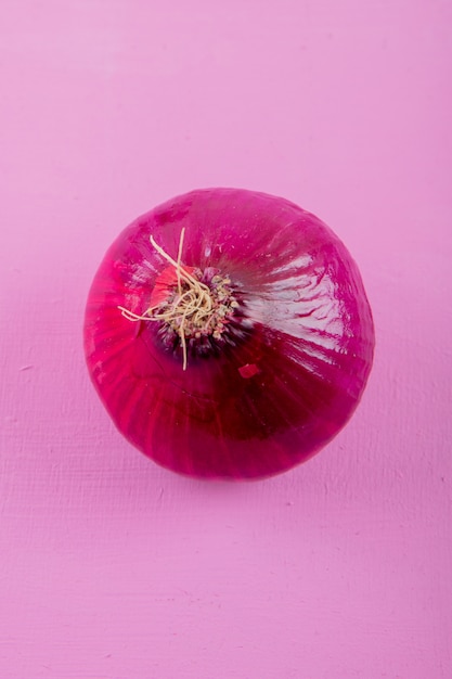 Close-up view of red onion on purple background with copy space