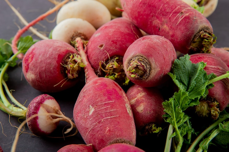 Free Photo close-up view of red radishes on maroon background