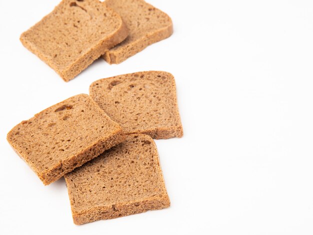Close-up view of rye bread slices on left side and white background with copy space