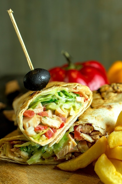 Free photo close up view of shawarma sandwich with chicken meat cabbage carrots sauce green wrapped in lavash