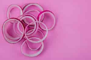 Free photo close-up view of sliced red onion on left side and purple background with copy space