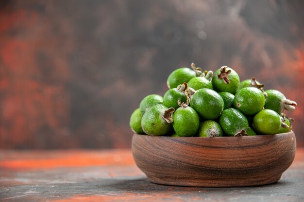 Close up view of small vitamin bomb green feijoas in a brown wooden pot