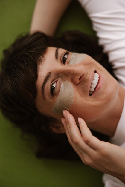 Close up view of smiling woman look at camera with eyes patches