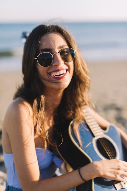 Free photo close up view of smiling woman with guitar