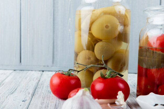 Close up view of sour green and red tomatoes on wooden surface and background with copy space