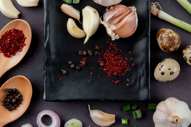 Close-up view of spices and vegetables as garlic egg onion on maroon background