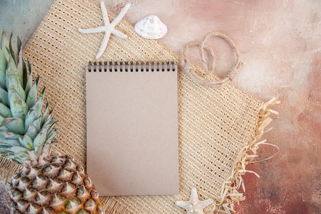 Close up view of spiral notebook and fresh grapefruit on soft colors background