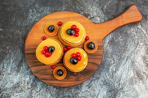 Close up view of stack of yummy pancakes on cutting board on gray