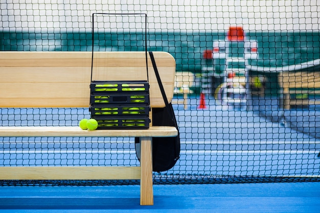 Close up view of tennis court through the net and balls and racket