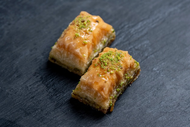 Close up view of traditional turkish baklava with pistachio on a black board