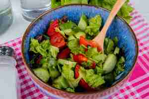 Foto gratuita vista del primo piano di insalata di verdure con sale sul panno del plaid