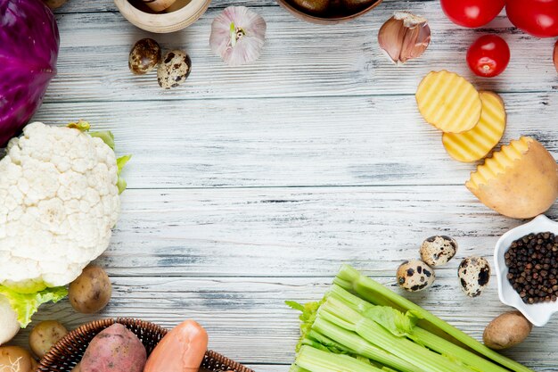 Close up view of vegetables as cauliflower potato egg garlic celery tomato with black pepper on wooden background with copy space