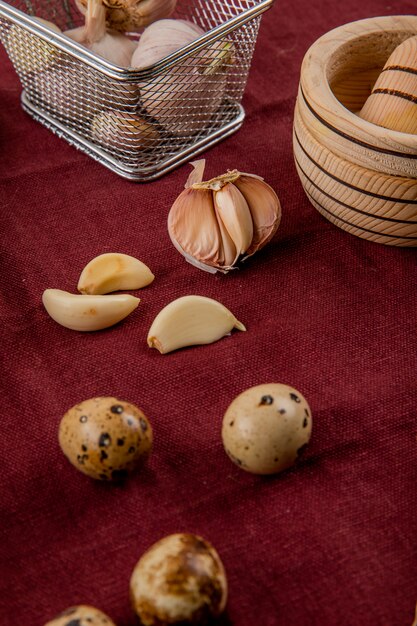 Close-up view of vegetables as garlic and mini egg on burgundy background