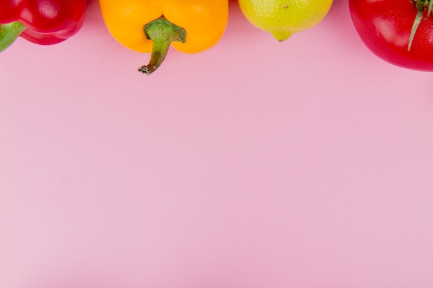 コピースペースと紫色の背景にレモンとペッパートマトとして野菜のクローズアップビュー
