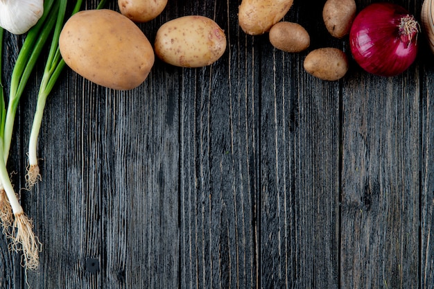 복사 공간 나무 배경에 감자 붉은 양파 scallion으로 야채를 볼을 닫습니다