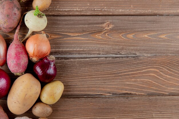 Close up view of vegetables as radish onion potato on wooden background with copy space